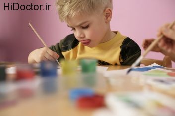 Little boy painting, sticking his tongue out